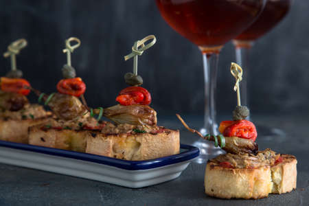  Pintxos Tapa on traditional plate, crispy bread, tuna, onion and pepper.