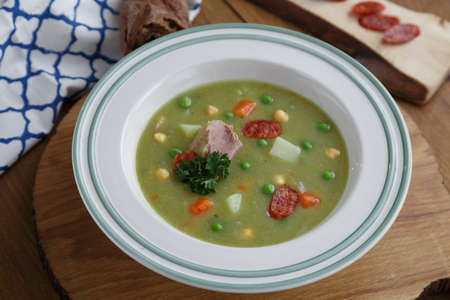 Pea soup with smoked sausage on wooden backgroundの写真素材