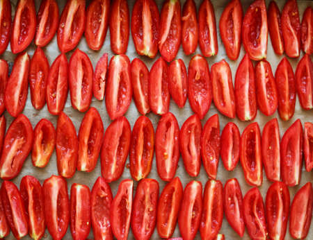 sliced tomatoes background on baked paper, top view