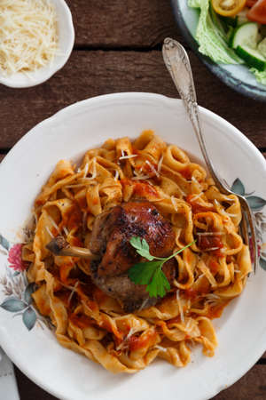 Italian homemade pasta, pappardelle with tomato sauce and braised rabbit, top view close-upの写真素材
