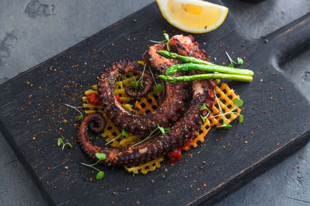 Grilled octopus with lemon and potatoesの写真素材