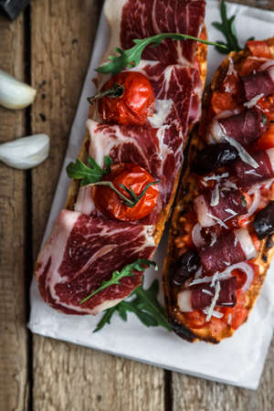 Traditional italian bruschetta with ham and wineの写真素材