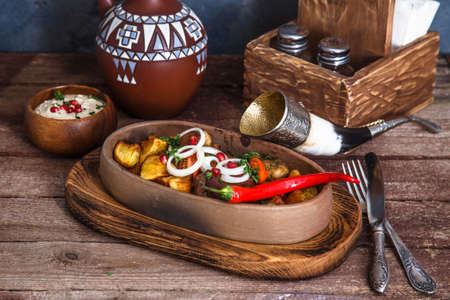 roasted pork and potatoes covered with onion and pomegranate seedsの写真素材