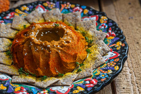 Red lentil hummus in traditional plate on the wooden tableの写真素材