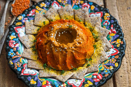 Red lentil hummus in traditional plate on the wooden tableの写真素材