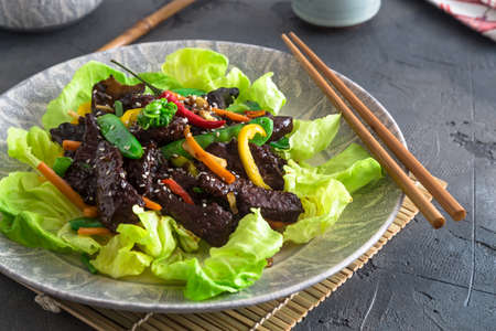 Asian stir fried chicken liver with bowl of rice and green tea. Close viewの写真素材