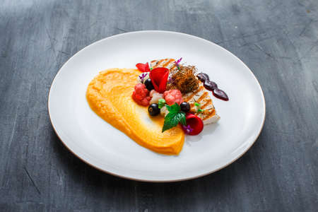 Grilled turkey fillet with pumpkin puree and vegetables on white plate. Close view.の写真素材