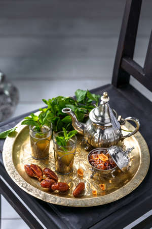 Moroccan mn tea in traditional glasses with mint, dates and sugarの写真素材