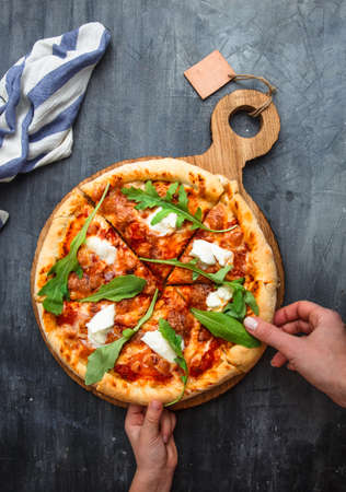 People Hands Taking Slices Of Pizza Margherita. Black background.の写真素材