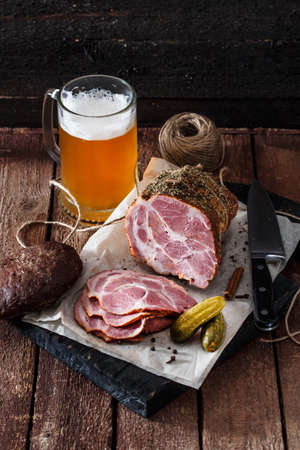 Smoked ham with rye bread, pickles and beer, rustic styleの写真素材