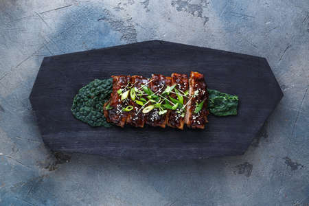 Honey glazed bbq ribs on black board, top view copy space.の写真素材