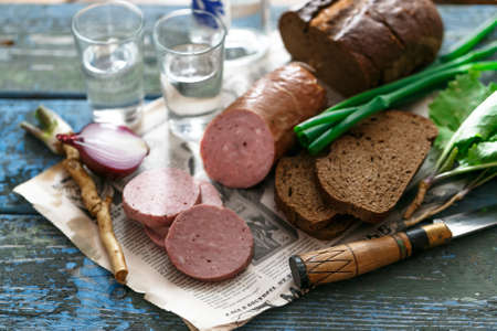 Sliced sausage with rye bread, onion and vodkaの写真素材