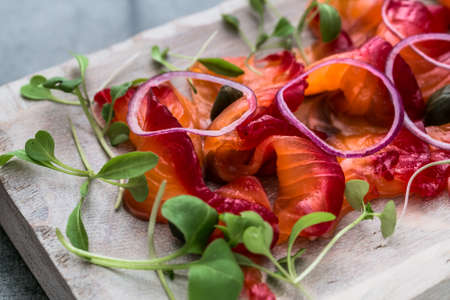 Close view sliced gravlax, cured salmon, on a white cutting board, backgroundの写真素材