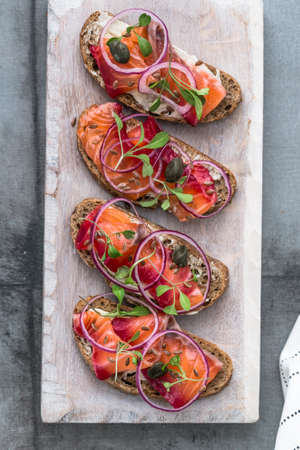 Cured salmon gravlax on a crusty bread, top viewの写真素材