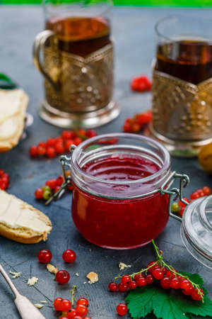 Red currants and jar of jam in gardenの写真素材