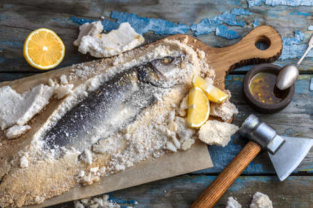 Fish baked in salt with lemon and oil, top viewの写真素材