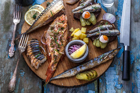 Fish plate with sturgeon, trout, perch, mackerel. Assorted fish on a plate.