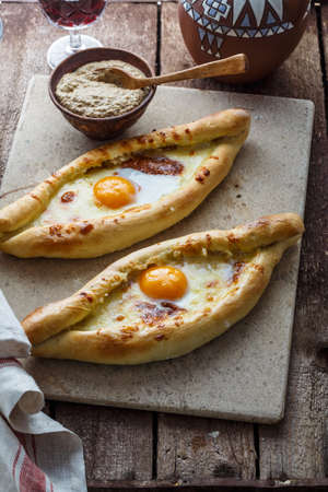 Ajarian khachapuri cheese bread with egg yolk, georgian breakfast, rustic style