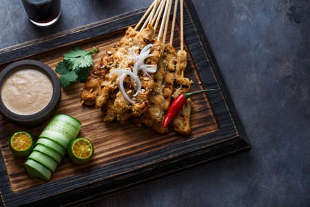 Chicken Satay or Sate Ayam - Malaysian famous food. Is a dish of seasoned, skewered and grilled meat, served with a peanut sauce. Top view copyspaceの写真素材