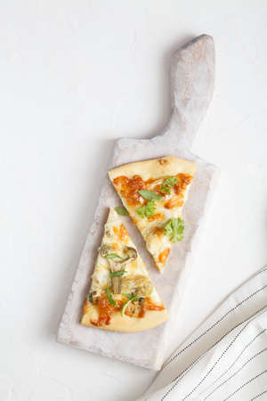 two pieces of white pizza with artichoke and arugulaの写真素材