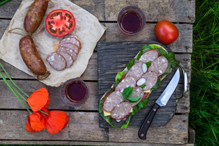 Sandwich with sausage slices, tomato and lettuce, top viewの写真素材