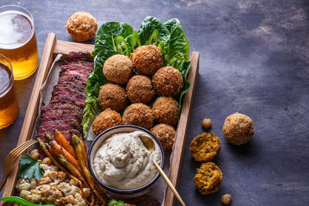 Close view of falafel, babaghanoush and pastrami in the wooden box, copyspace.の写真素材