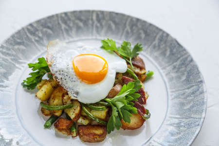 Breakfats with fried egg, potato and garlic sprouts.の写真素材