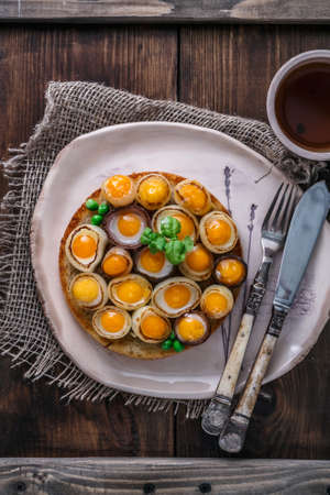 Fried quail eggs and onion on toasted bread, copy spaceの写真素材