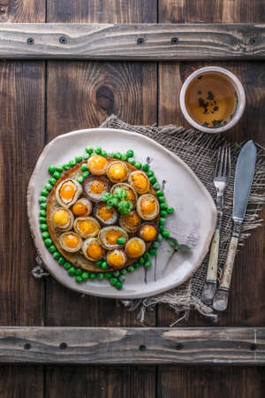 Fried quail eggs and onion on toasted bread, copy spaceの写真素材