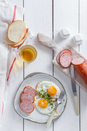 Sunny side up eggs with sausage and toastの写真素材