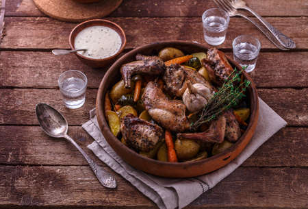 Rabbit baked with potatoe and herbs in a pot, copy spaceの写真素材