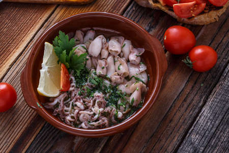 Grilled baby with garlic and lemon on wooden backgroundの写真素材