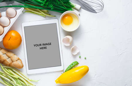Cooking recipes on tablet with vegetables on background, copy spaceの写真素材