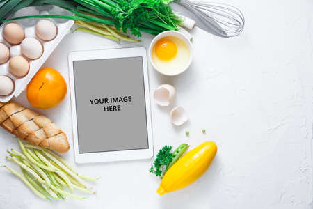 Flat lay with Tablet computer with fresh vegetables on white background, copy spaceの写真素材