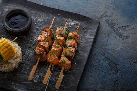 Salmon skewers with miso close view with noodles and corn, copy space.の写真素材