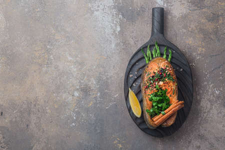 Fried salmon steak with vegetables on wooden boardの写真素材