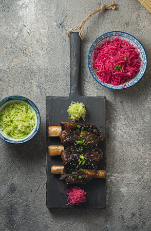 Beef ribs, korean style on black wooden board, top view
