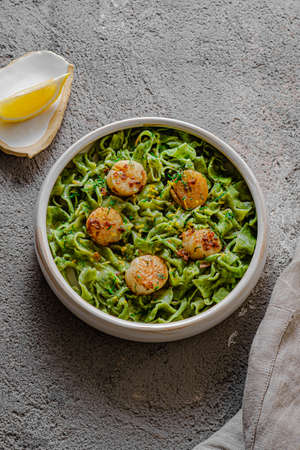 Green homemade spinach pasta with scallops and sauce, close viewの写真素材