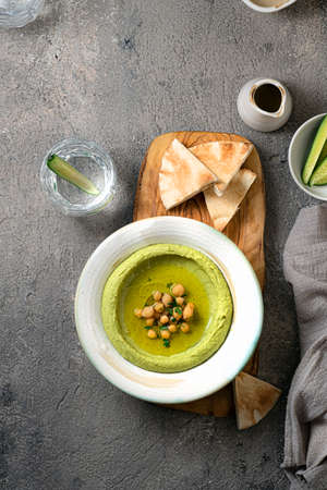 A plate of green hummus with chickpeas and pita breadの写真素材