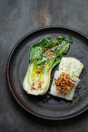 Tasty fried halibut fillet with bok choi, restaurant dish, top viewの写真素材