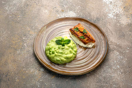 Pan seared white fish fillet with edamame puree on rustic backgroundの写真素材