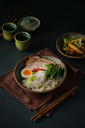 Asian noodle soup on table, ramen with pork, vegetables and egg in a bowl. Copy spaceの写真素材