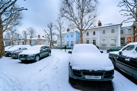 LONDON - ENGLAND, 18 DEC 2010: Snow covered, cosy street in Holland Park, London. (St James?s Church in the middle.)のeditorial素材
