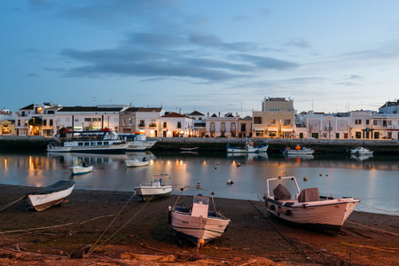 Tavira, Portugal - April 11; 2018: Fishing boats at the bank on the Gilao River in the Old Town of Tavira, Algarve, Portugal.の写真素材