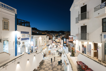 Albufeira, Portugal - April 14: Night view of the famous  R. 5 de Outubro Shopping Street in the Old Town of Albufeira, Algarve, Portugal. Albufeira is a coastal city in the southern Algarve region of Portugal. Itâs a former fishing village that has becのeditorial素材