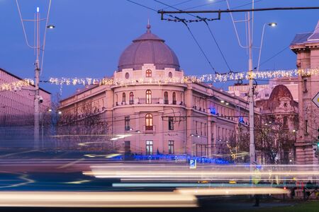 Bucharest, Romania - Dec 16, 2019:  Rush hour in University Square, Bucharest, in downtown Bucharest at dusk; and the Bucharest National Theater (TNB) in the backgroundのeditorial素材