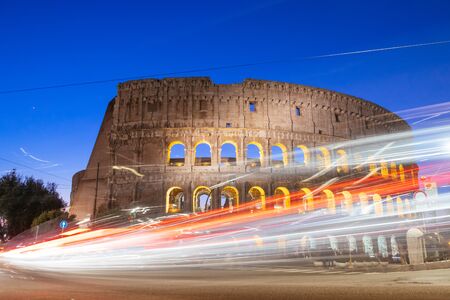 Colosseum at night with colorful blurred traffic lights