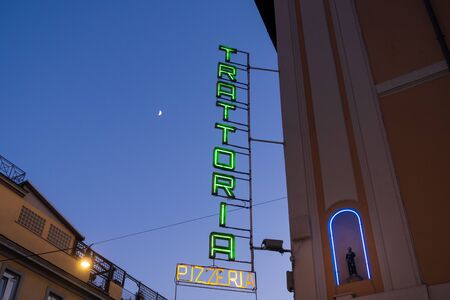 Rome, Italy - Jan 2, 2020: A green neon Trattoria sign on the side of a building in Rome, Italy. A Trattoria is an Italian eating establishment, less formal than a Ristorante.のeditorial素材