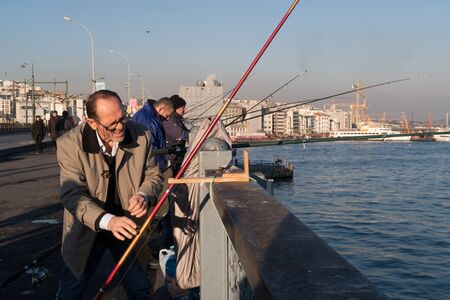 Istanbul, Turkey - Jan 10, 2020: Fishermen on the Galata Bridge, in Eminonu district in background Beyoglu district, Istanbul. Turkeyのeditorial素材