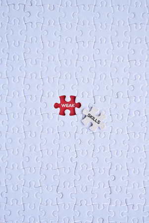 'Weak and skills' word on white puzzles with red background flat lay concept.